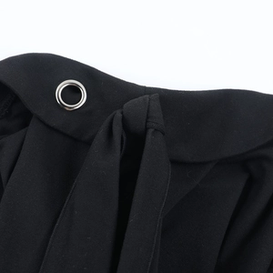Detail der Metallösen und Schnürung an einem schwarzen One-Shoulder-Langarm-Top für Damen
