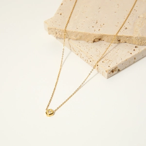 Minimalist gold stainless steel necklace with hexagonal white zircon pendant on stone