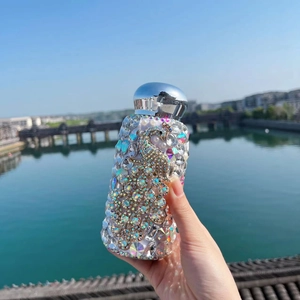 Outdoor handheld view of a luxury peacock vacuum flask with handmade rhinestone crystals