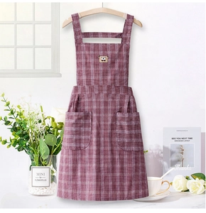 Detail of purple plaid apron with bear badge and front pockets in a cozy kitchen setting