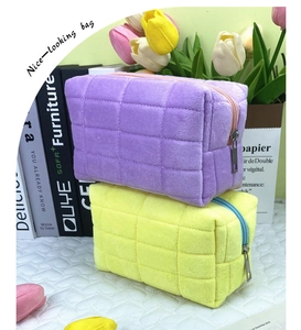 Detail of purple and yellow quilted plush pencil pouches in a cozy desktop setting