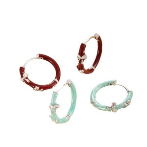 Retro bow hoop earrings in burgundy and mint green enamel finish on white background