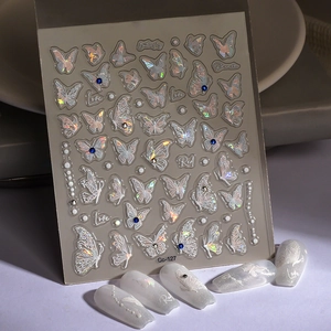 Macro detail of holographic butterfly nail stickers with shiny 3D relief on white nails