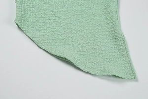 Détail du tissu vert pistache avec texture gaufrée 3D et finition de bordure nette