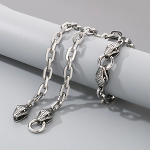 Detailed macro view of silver steel snake head pendants on rectangle link chain jewelry