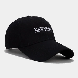Close-up of white NEW YORK embroidery on a black cotton baseball cap with curved brim