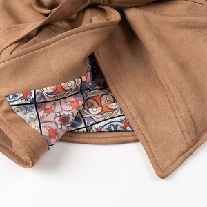 Detail view of brown faux suede jacket featuring waist tie and floral paisley lining