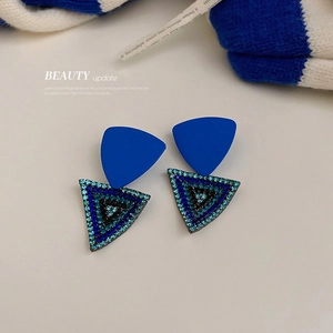 Klein blue geometric triangle earrings with rhinestones on a minimalist white background