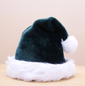 Detailed view of dark green plush Christmas hat with white faux fur trim on wood