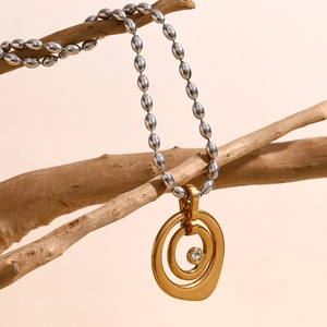 Detail of 18K gold irregular double ring pendant with rhinestone on silver bead chain