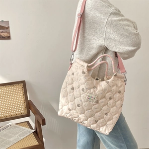 Détail du sac fourre-tout matelassé rose avec motif ours et bandoulière réglable