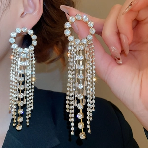 Macro shot of long sparkling rhinestone tassel earrings with a round crystal stud design