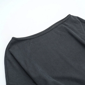 Detail of dark grey knit top showing refined ribbed texture and off-shoulder neckline