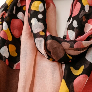 Close-up of lightweight scarf featuring colorful mosaic pebble pattern and sheer fabric
