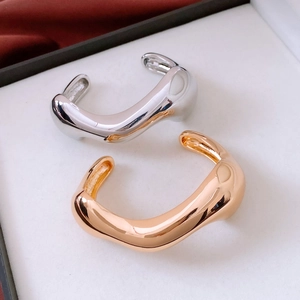 Polished gold and silver irregular cuff bracelets on elegant satin background