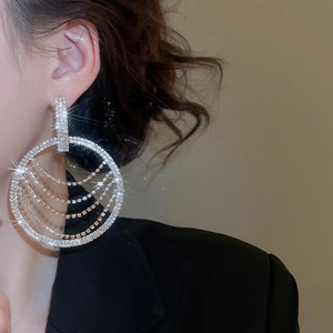 Détail de créoles de luxe avec pampilles en strass scintillantes sur un mannequin
