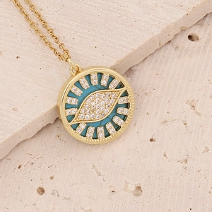 Close-up of gold eye pendant featuring turquoise center and micro-pave zircons
