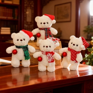 Orsetti di peluche natalizi con cappelli da Babbo Natale e sciarpe su tavolo di legno