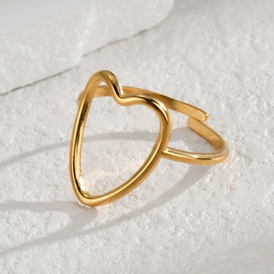 Elegant gold open heart ring on a white stone background minimalist jewelry style
