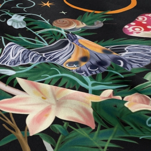 Macro detail of high-quality fabric showing floral, mushroom and moth patterns
