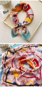Detailed view of silk-like square scarf featuring white deer and floral art patterns