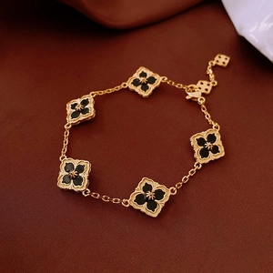 Detail view of 14K gold plated clover bracelet with black petals and beaded edge finish
