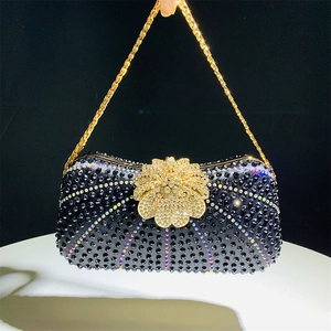 Detail of evening clutch with black rhinestones and golden floral rhinestone clasp