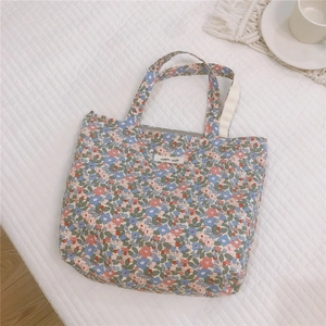 Vista dettagliata della borsa in cotone a fiori con delicati motivi di petali blu e rosa