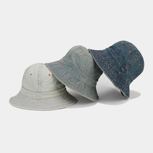 Détail de bobs en denim déclinés en trois tons de bleu avec des coutures orange contrastées