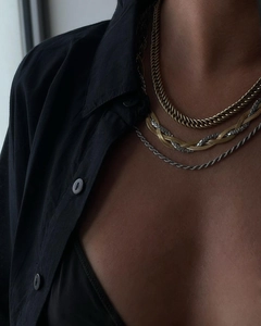 Close-up of layered two-tone necklace with gold cuban chain and silver twisted rope styles