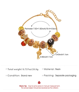 Detail of leopard print beads and charms on a gold-plated resin charm bracelet