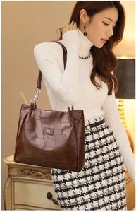 Detail of brown faux leather tote with geometric stitching and silver chain strap link