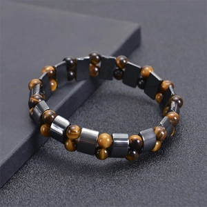 Macro detail of tiger eye beads and hematite stones on an elastic therapy bracelet