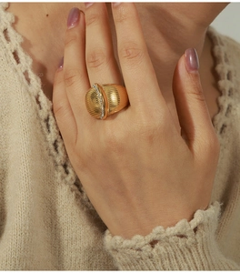 Macro detail of gold-plated ribbed ring with vertical zircon inlay worn on finger