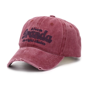 Macro detail of distressed washed cotton baseball cap with blue letter embroidery