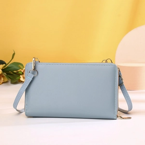 Detailed macro of a light blue crossbody phone wallet with elegant gold metal zippers
