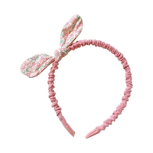 Floral print rabbit ear headband for girls, pink fabric hair accessory on white background