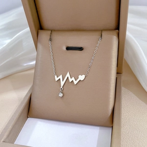 Detailed macro view of heartbeat pendant with crystal on silk in beige jewelry box