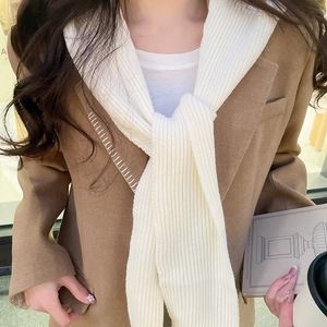 Detail shot of a white ribbed knit hooded scarf paired with a brown wool blazer jacket