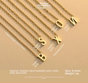 Polished gold stainless steel initial necklaces displayed on a neutral background