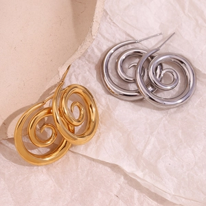 Minimalist spiral swirl earrings in gold and silver finish on textured background