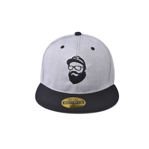 Detail of grey and black flat brim cap featuring character embroidery and gold label