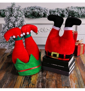 Detail of Christmas elf legs and Santa hat with bells and buckles for festive party decor