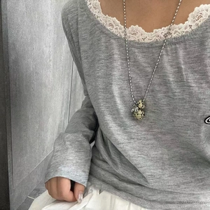 Detail of dalmatian jasper stone pendants on long silver chain worn by model