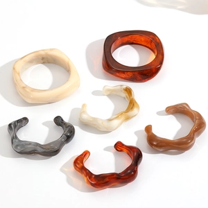 Minimalist marble resin bangles in amber and beige colors with irregular wave designs