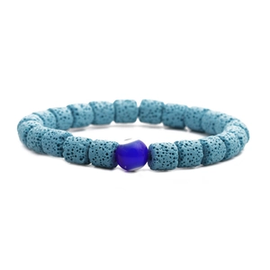 Makro-Detail von blauen Lavaperlen und dem zentralen Evil-Eye-Charm am Armband