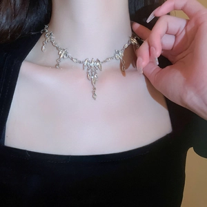 Close-up of silver rhinestone oval fringe necklace on a model showing elegant diamond details