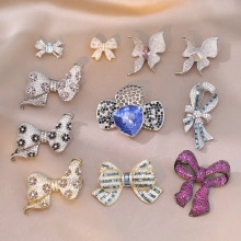 Detailed close-up of crystal bow brooches with rhinestone accents on satin fabric