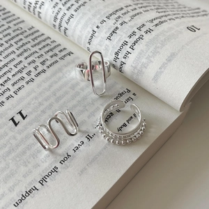 Detailed view of minimalist 925 sterling silver geometric rings on an open book