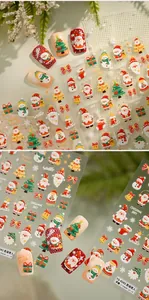 Dettaglio di adesivi 3D per unghie natalizie con motivi di Babbo Natale e pupazzo di neve